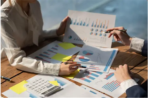 Equity research analysts reviewing charts and data during the report creation process
